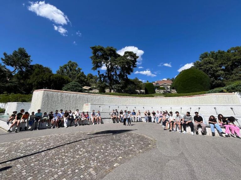 Summer camp group gathered in front of an open-air amphitheatre