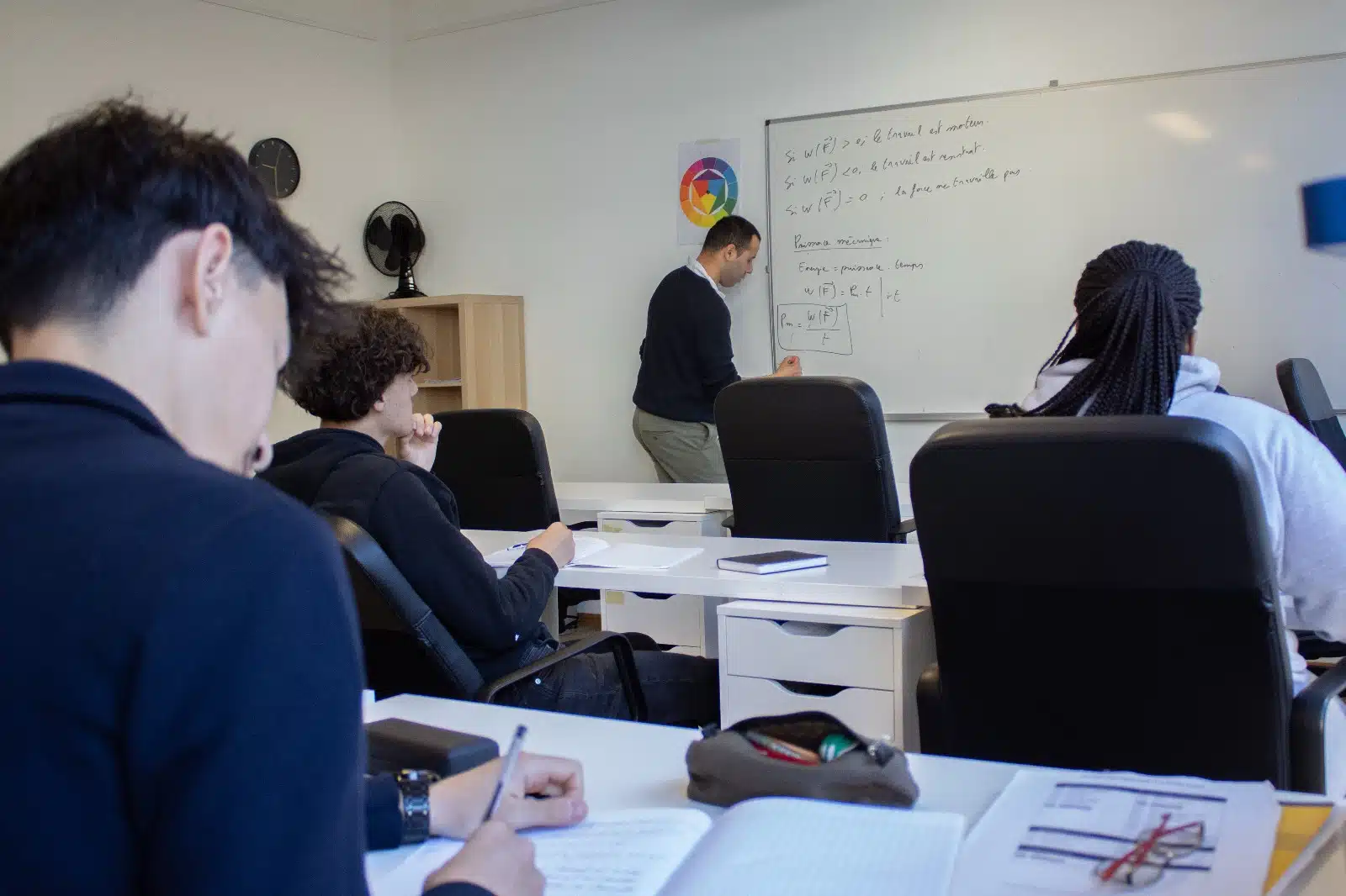 Enseignant de mathématiques au tableau devant des élèves de Chantemerle